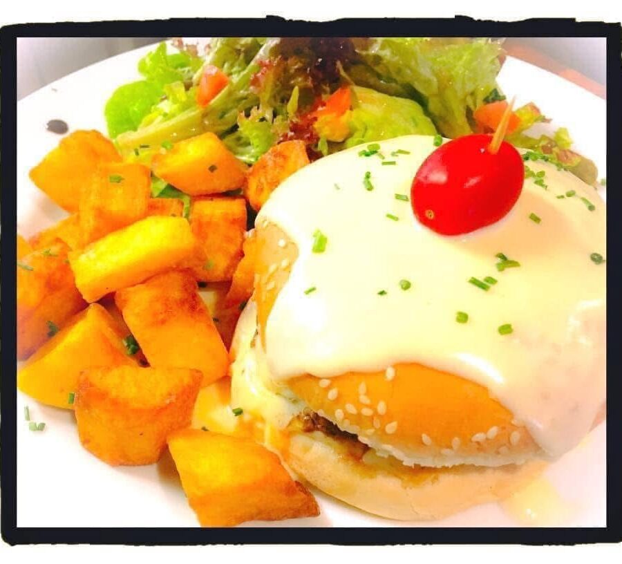 Burger gourmand au fromage fondu avec pommes de terre sautées et salade