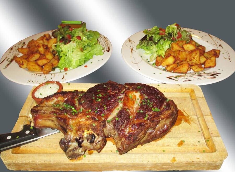 Côte de boeuf grillée servie avec salade mesclun et pommes de terre sautées