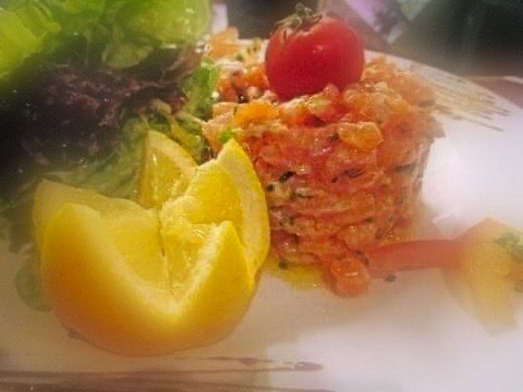 Tartare de saumon frais servi avec salade verte et quartiers de citron – Au Petit Zinc Lyon
